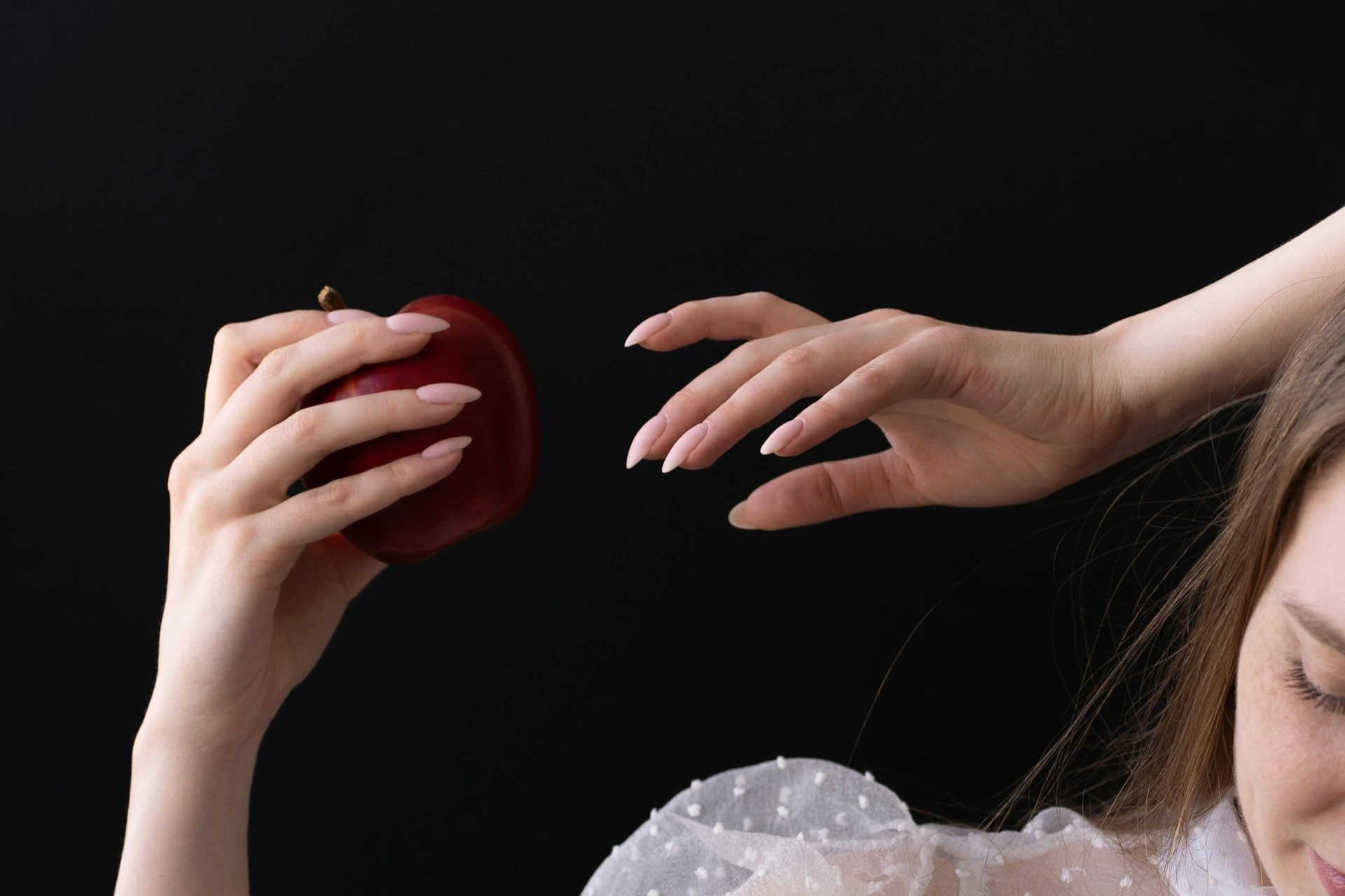 A woman holding an apple in her right hand