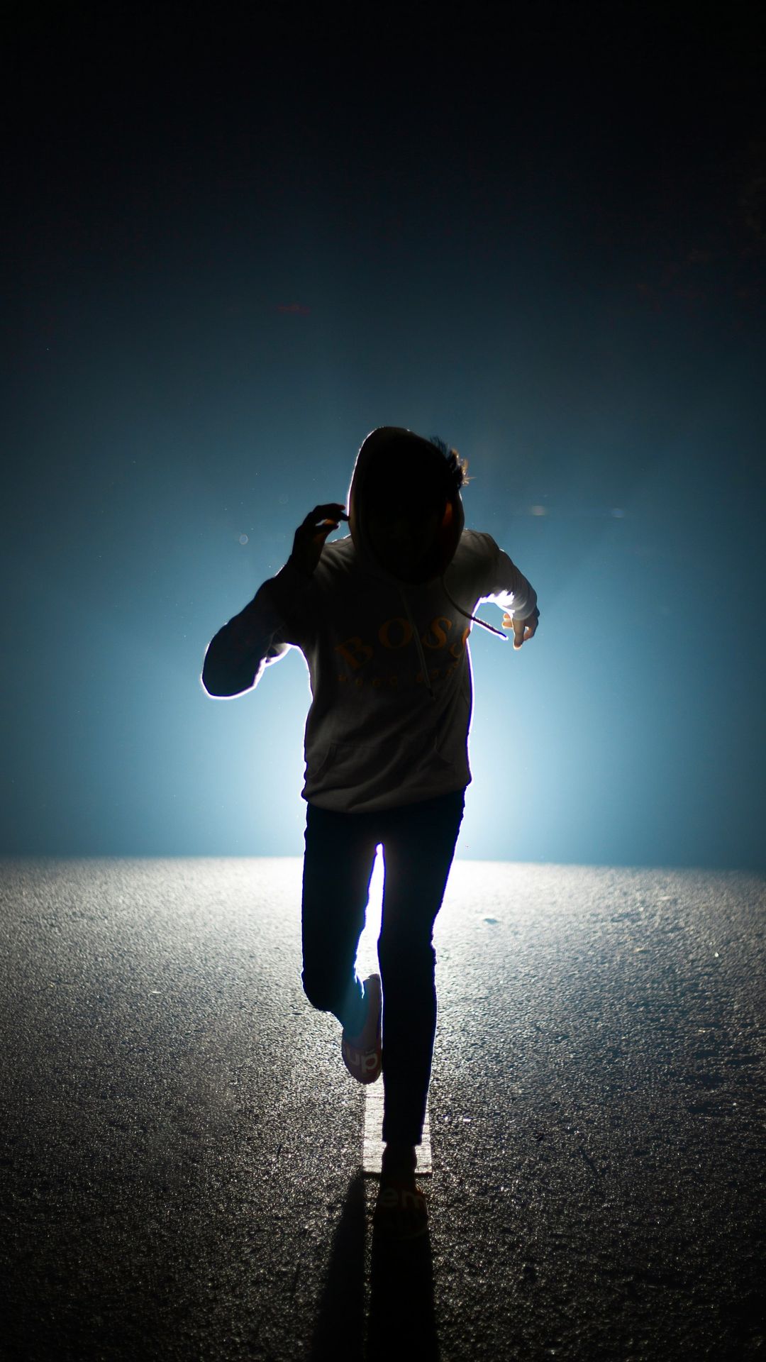 a person walking in the middle of the road at night