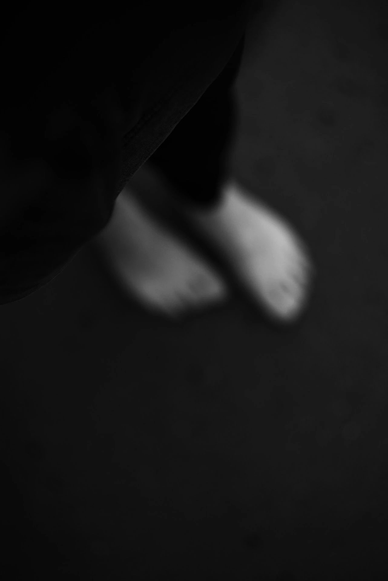 Blurry bare feet on a dark ground.