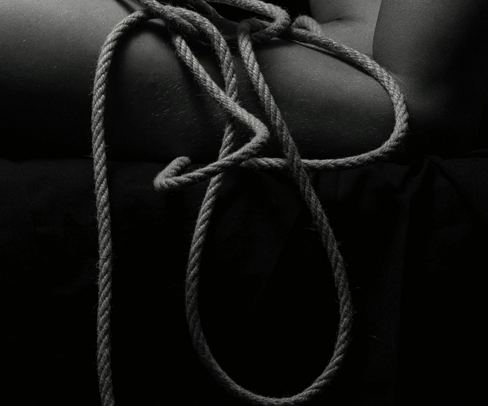 a black and white photo of a person holding a rope