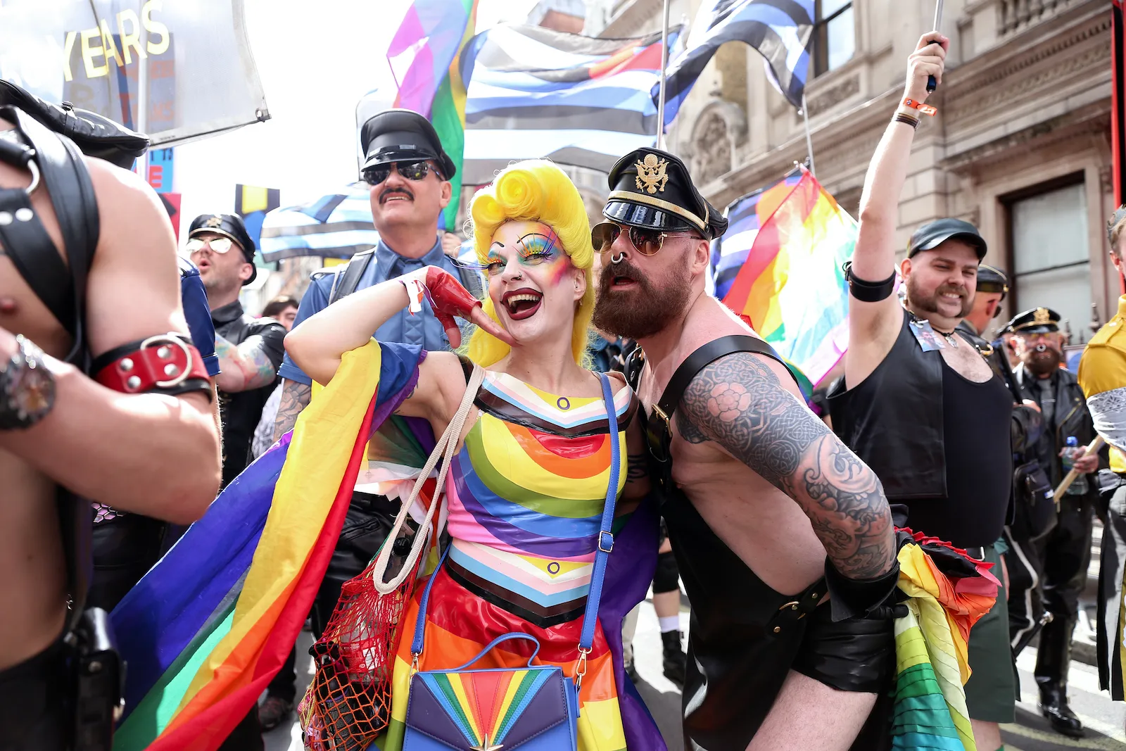 Một drag queen chụp ảnh cùng người đang ông xỏ khuyên đội nón trong diễu hành tự hào