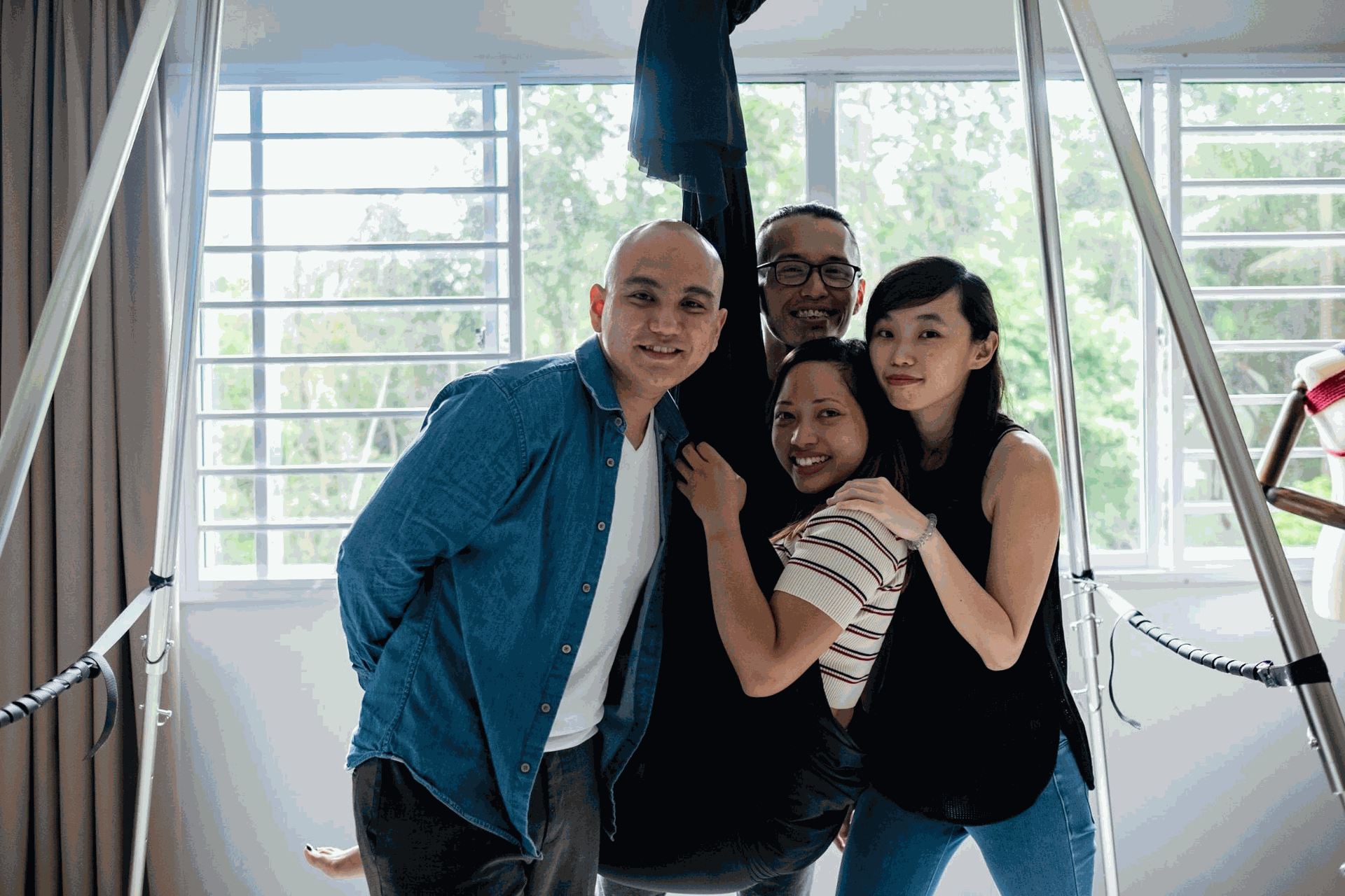 bốn người đang đùa giỡn và cười nhìn vào camera