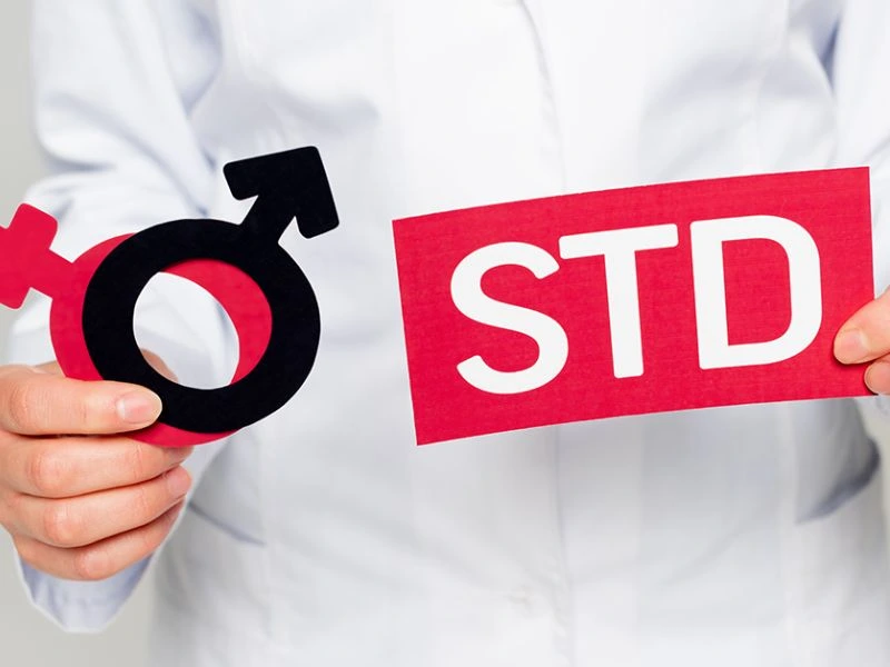 hand holding an STD and gender sticker